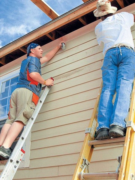 Pose de parement sur la façade d'une maison en bois Pose de parement sur la façade d'une maison en bois