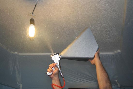 Travailler avec un pistolet lors de l'application de plâtre au plafond Travailler avec un pistolet lors de l'application de plâtre au plafond