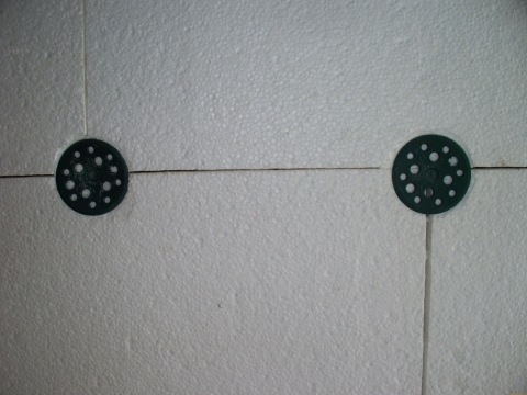 Nous voyons un exemple de fixation de mousse avec des chevilles avec des bouchons en plastique, afin d'éviter sa destruction